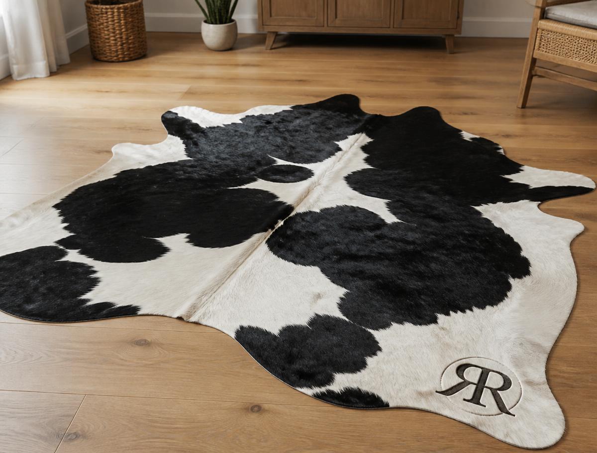 Full-size cowhide branded with a family monogram in a Magnolia TX home